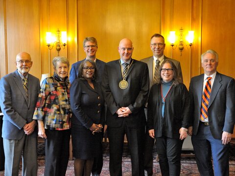 A group photo of the investiture speakers who are standing side by side in the south lounge of Illini Union.