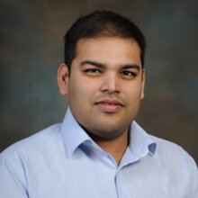 Head shot of Angad Mehta on a dark background