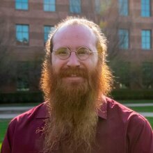 Head shot of Zane Thornburg outdoors with a building in the background