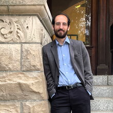 Paul J. Griffin stands leaning against one side of the stone archway leading to the entrance of Noyes Laboratory.