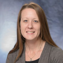 Head shot of Elise McCarren on a blue background