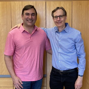 Portrait of Milan Mrksich and Steve Zimmerman standing side by side against a light brown wall