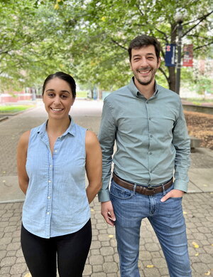 Portrait of Anastasia Manesis and Majed Fataftah standing next to each other on a brick walkway lined with trees on the UIUC campus.