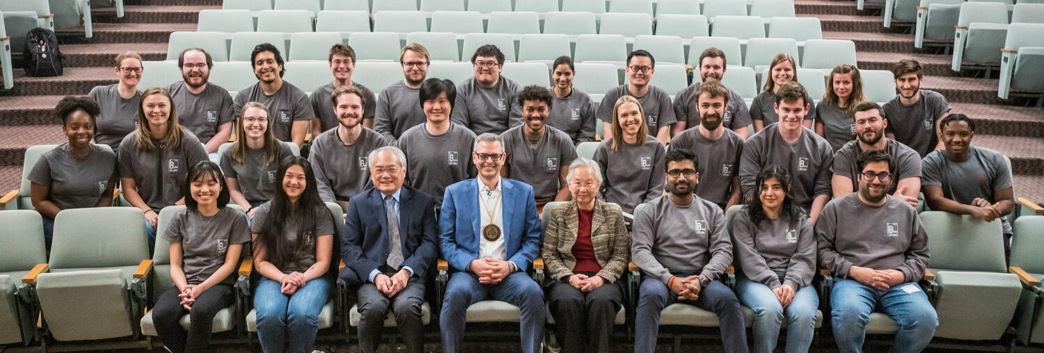 Photo of Martin Burke, May and Ving Lee and all of the Burke Group members sitting in the auditorium chairs.