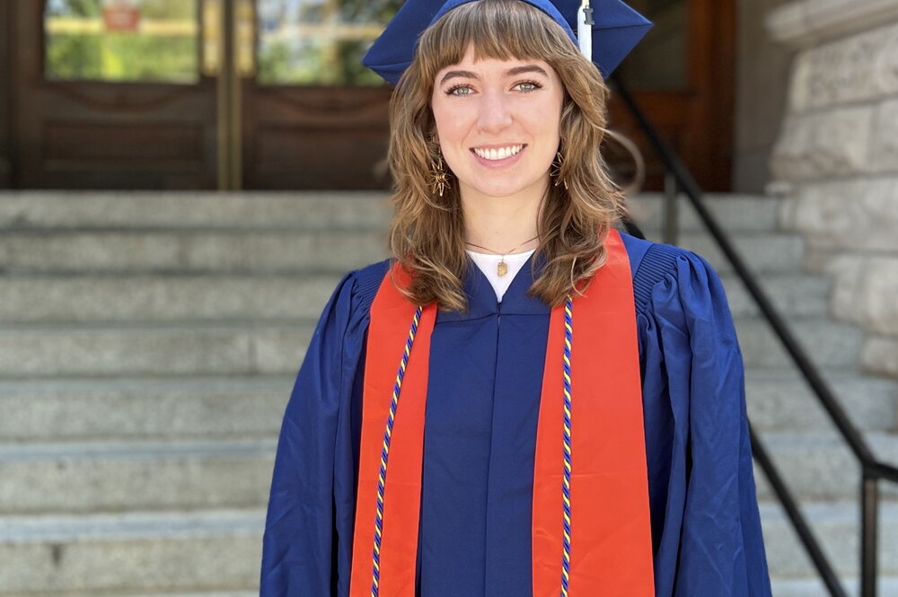 Megan Murphy in cap and gown in front of Noyes entrance