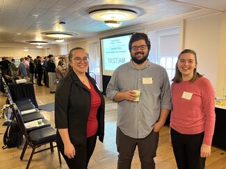 Graduate students stand side by side at research event.